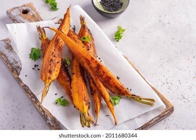 Glazed And Roasted Young Red Carrots On A Piece Of Baking Paper, White Background