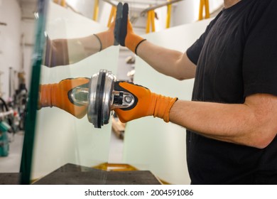 Glazier holding a thick pane of glass with a suction cup, Glass Factory, Specialist work tools 