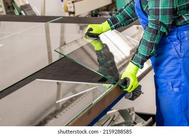 The glazier removes the cut glass from the specialized table in the glass factory, Cutting glass panels 
