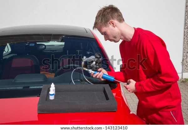 Glazier repairing windshield on a car after
stone-chipping damage