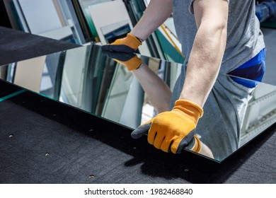 the glazier takes a piece of mirror off the table. Glass factory, manufacture  - Shutterstock ID 1982468840