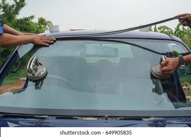 Glazier using tools repairing fix crack broken windshield on the front window glass wiper of the machine car accident. vehicle services replace windscreen.