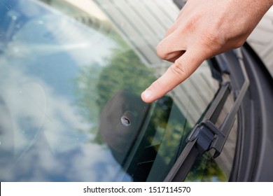 Glazier windscreen on Broken car windshield glass from stone pointed watch of finger hand - Powered by Shutterstock