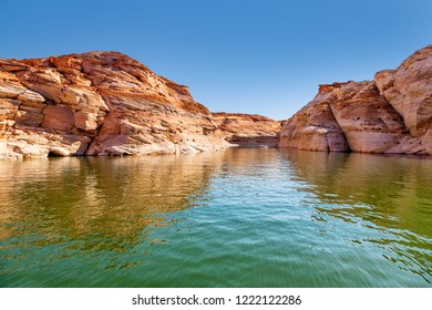Glen Canyon coloured sandstone cliffs filled with water, near Lake Powell and the Colorado River, straddling the border between Utah and Arizona. National park and popular tourist attraction