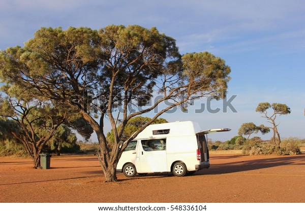 GLENDAMBO, ALICE SPRINGS, AUSTRALIA - November\
30, 2015. Hightop camper van in shadow place at abandoned camping\
in remote Outback area along Stuart Highway to Darwin. Freedom and\
good life concept.