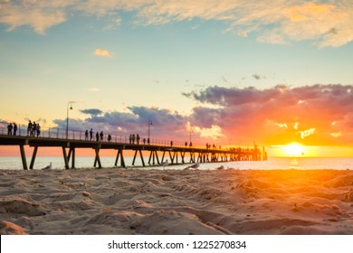 Glenelg beach with people walking along jetty at sunset, South Australia. Focus on sand - Shutterstock ID 1225270834