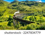 Glenfinnan Railway Viaduct in Scotland with the steam train passing over