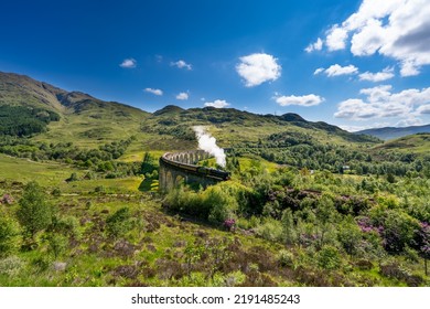 Glenfinnan Railway Viaduct In Scotland With The Steam Train Passing Over