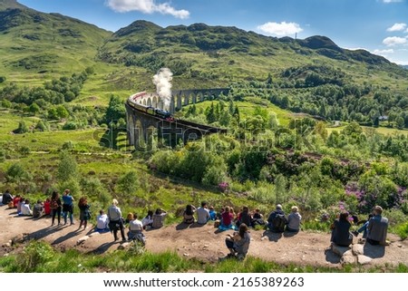 Glenfinnan Railway Viaduct seen by group of tourists in Scotland 