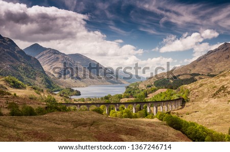 The Glenfinnan Viaduct carries the West Highland Railway Line high above Glen Finnan valley beside the lochs and mountains of Scotland.
