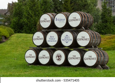 GLENLIVET, MORAY, SCOTLAND - SEPTEMBER 14, 2015: Stacked pile wooden The Glenlivet whisky barrels in front of the distillery