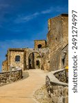 A glimpse of the ancient medieval village of Celleno, Viterbo, Italy. Ghost town, with houses in ruins, abandoned and uninhabited. The castle walls and the road with the arch leading to the town.