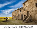 A glimpse of the ancient medieval village of Montecalvello, Viterbo, Italy. The internal courtyard of the castle with the ancient stone and brick buildings and the fountain in the center.