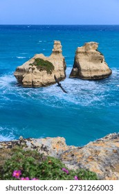 Glimpse of the sea stack Due Sorelle (Two Sisters) on the Torre dell'Orso Bay in Apulia, Italy.