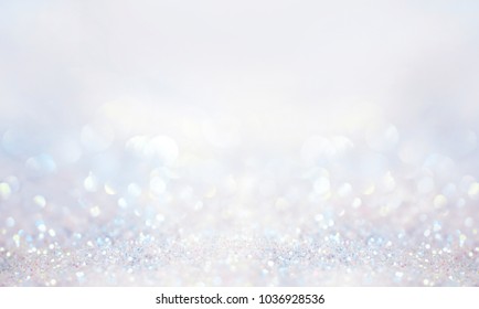 Glitter background in pastel delicate silver and white tones de-focused.
