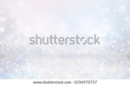 Glitter christmas background in pastel delicate silver and white tones de-focused.