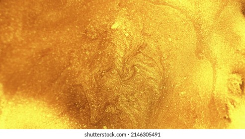 Glitter fluid. Wet ink texture. Shiny liquid spill. Glossy polish. Defocused golden color shimmering paint flow abstract art background.