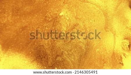 Glitter fluid. Wet ink texture. Shiny liquid spill. Glossy polish. Defocused golden color shimmering paint flow abstract art background.