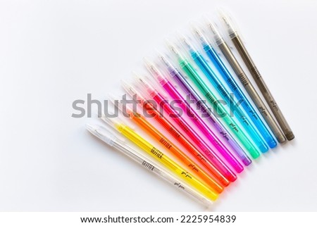 Glitter gel pens bright vivid colors on white paper background