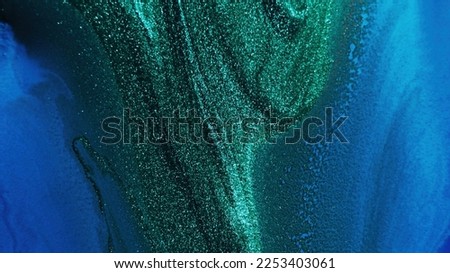 Glitter ink. Abstract background. Sparkling wave. Defocused shiny shimmering green blue color liquid paint blend grain texture with free space.