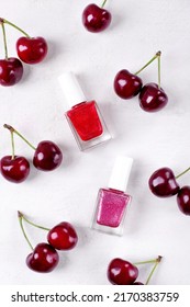 Glitter Nail Polish Of Two Berry Colors On White Background With Cherries. Mockup With Unlabeled Products. Flat Lay