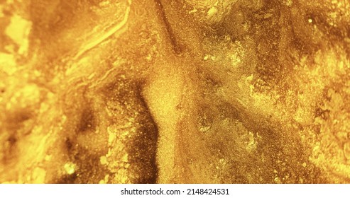 Glitter paint flow. Molten gold texture. Floating ink. Defocused yellow bronze color sparkling fluid leak abstract art background.