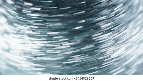 Glitter pattern. Fast motion effect. Dynamic light. Defocused silver color shiny sparkle sequin texture shimmering long exposure glow trails abstract art background.