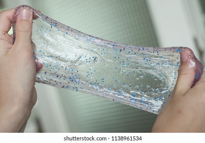 Glitter Slime Being Stretched Between Hands