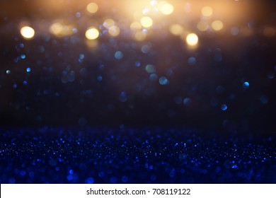 Glitter Vintage Lights Background. Blue, Gold And Black. De Focused.