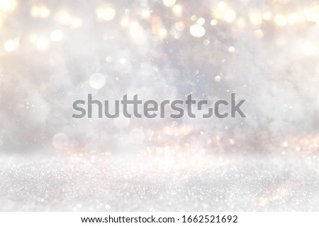 glitter vintage lights background. gold, silver and white. de-focused