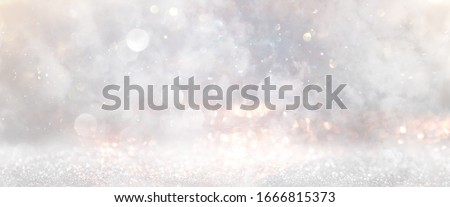 glitter vintage lights background. gold, silver and white. de-focused