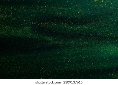 Glittering flows of gold particles in green fluid. Various stains and overflows of gold particles in liquid. Abstract shimmering background with flows of golden glitters dust. - Powered by Shutterstock