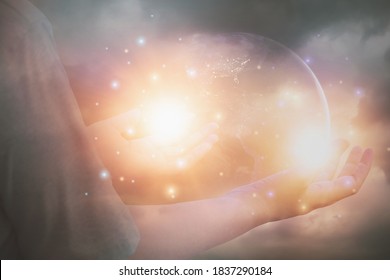 Glitzerndes Licht durch die Hand glänzende Frauen, die die Hände heben, um für den Segen, den Planeten und den Hintergrund des Sonnenuntergangs zu beten Heiligung, Konzept des reinen Geistes und der Spiritualität,Element Bild von der NASA