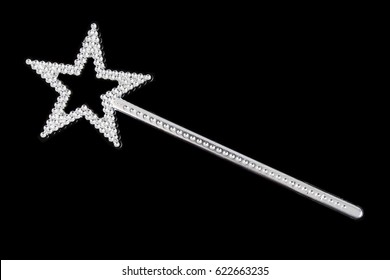 Glittery silver magic wand with star on black background.