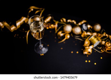 Gllasses Of Champagne On Black Stylish Background With Place For Text. Festive Concept.Golden Stylish Decoration On Black Background.  Sticky Tape, Christmas Balls, Golden Ribbon