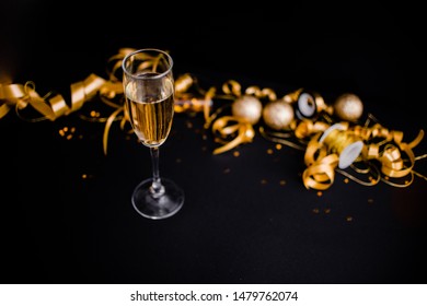 Gllasses Of Champagne On Black Stylish Background With Place For Text. Festive Concept.Golden Stylish Decoration On Black Background.  Sticky Tape, Christmas Balls, Golden Ribbon