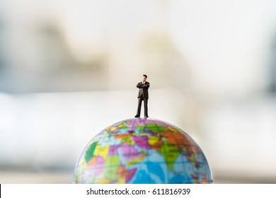 Global and Business Concept. Businessman miniature people figure standing on mini world ball model. - Powered by Shutterstock