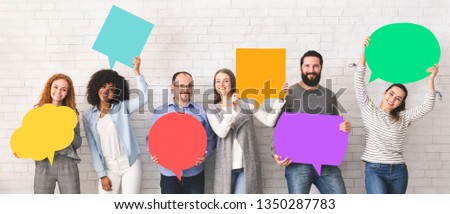 Global communications. Group of happy young diverse people holding empty colorful speech bubbles and smiling at camera