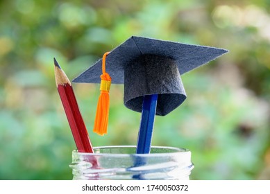 Global education success / graduate study aborad program concept : Black graduation cap or a mortarboard, blue and red pencils in a bottle, depicts achievement in higher mba learning course in academy