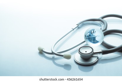 Global healthcare. Globe and stethoscope blue tone on white background