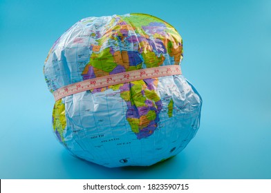 Global Obesity Epidemic Crisis Affecting Increasing Numbers Of Earth Population And Chronic Health Condition Concept With Globe And Measuring Tape Isolated On Blue Background