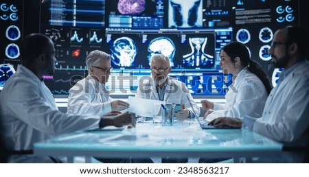 Global Pharmaceutical Research and Manufacturing Company Having a Meeting with a Group of Multiethnic Scientists, Doctors and Surgeons in a Room with Big Digital Screen with Patient Health Data