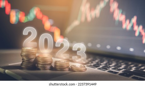 Global recession and financial crisis in 2023 concept, reduced coins placed on laptop. Screen background showing stock market graphs, funds and investments. - Shutterstock ID 2237391449