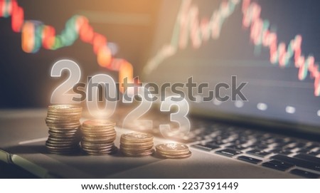 Global recession and financial crisis in 2023 concept, reduced coins placed on laptop. Screen background showing stock market graphs, funds and investments.