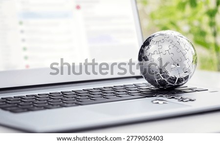 Global strategy solution concept - chrome earth jigsaw puzzle on laptop keyboard