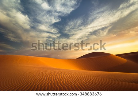 Global warming concept. Lonely sand dunes under dramatic evening sunset sky at drought  desert landscape