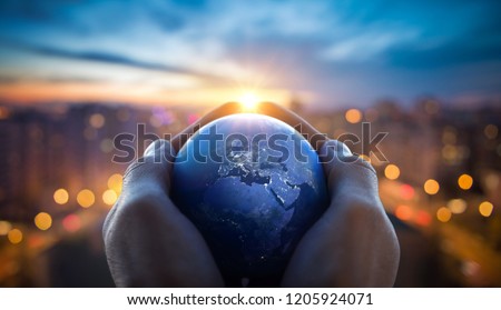 The globe Earth in the hands of man against the night city. Concept on business, politics, ecology and media. Earth day abstract background. Elements of this image furnished by NASA.
