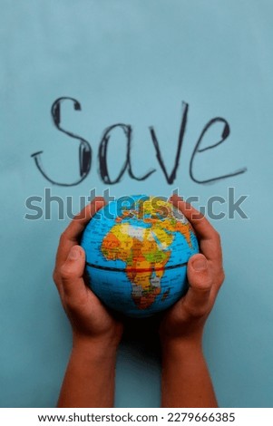 the globe in the hands of a child against the background of garbage, save the planet, call