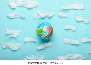 Globe on a blue background with clouds. Top view. Minimalism