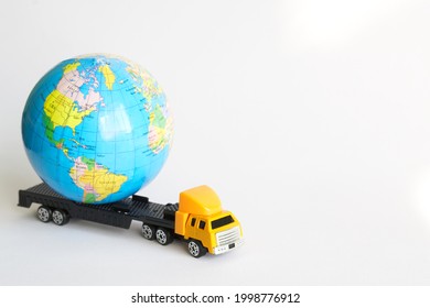 Globe on a toy truck with a trailer. The concept of worldwide delivery of goods and parcels, collection, work with fragile and important orders. Free space for an inscription. White background